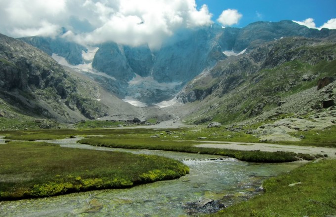 Pradera a los pies del Macizo y Glaciar del Vignemale con el río Oulettes de Vignemale formando pequeños meandros